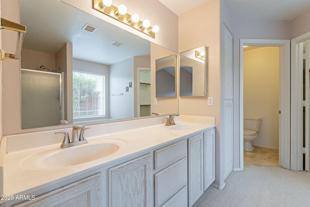 bathroom featuring a sink, visible vents, toilet, and a shower stall