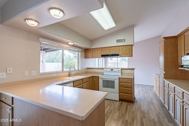 kitchen featuring white appliances, a peninsula, visible vents, and under cabinet range hood