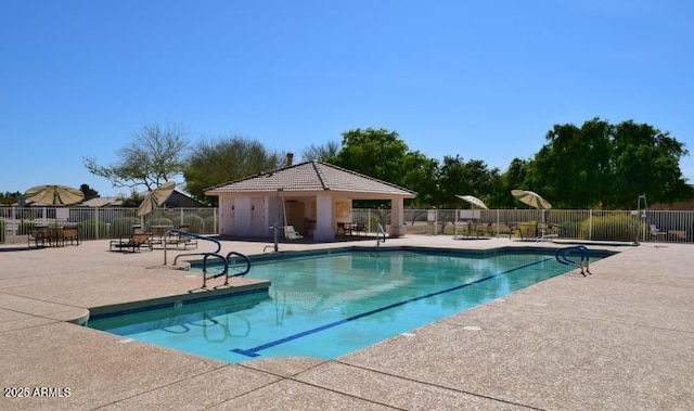 pool with a patio and fence