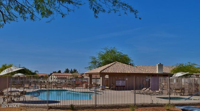 community pool with a patio and fence