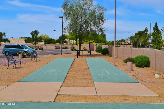 view of home's community featuring shuffleboard and fence