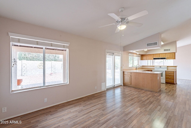 kitchen featuring visible vents, a peninsula, light countertops, and white electric range