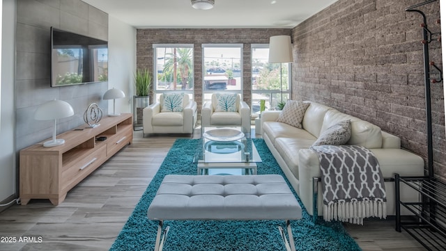 living room featuring brick wall and light wood-style flooring