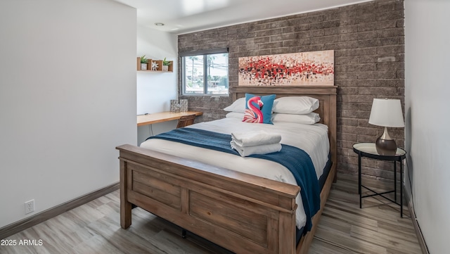 bedroom with baseboards and wood finished floors