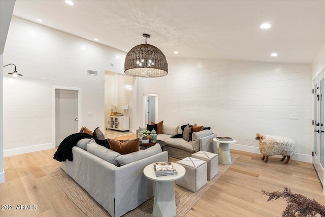 living room with vaulted ceiling and light wood-type flooring