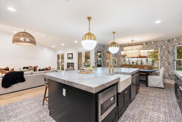 8014 E Del Tesoro Dr, Scottsdale, AZ 85258 - kitchen featuring a sink, open floor plan, wallpapered walls, dark cabinetry, and stainless steel microwave