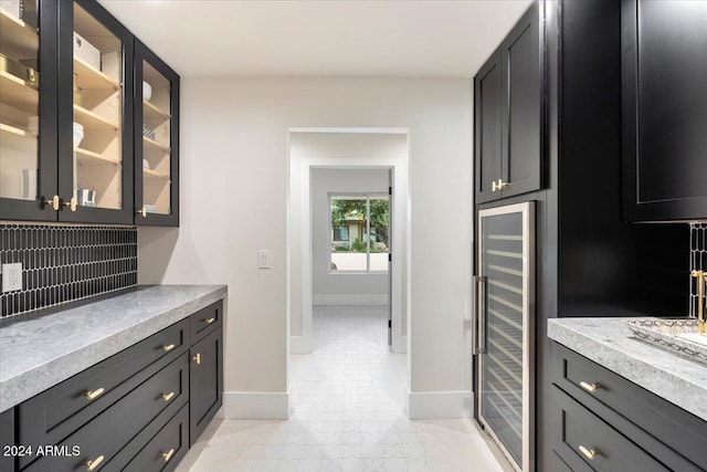 8014 E Del Tesoro Dr, Scottsdale, AZ 85258 - kitchen featuring wine cooler, baseboards, glass insert cabinets, light countertops, and backsplash