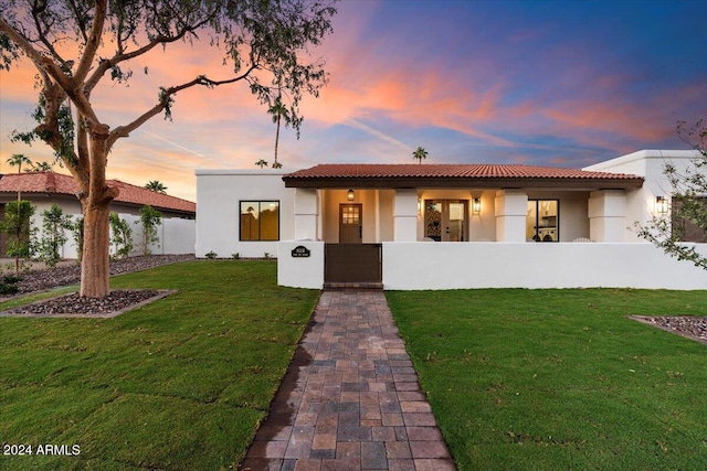 mediterranean / spanish home featuring a lawn