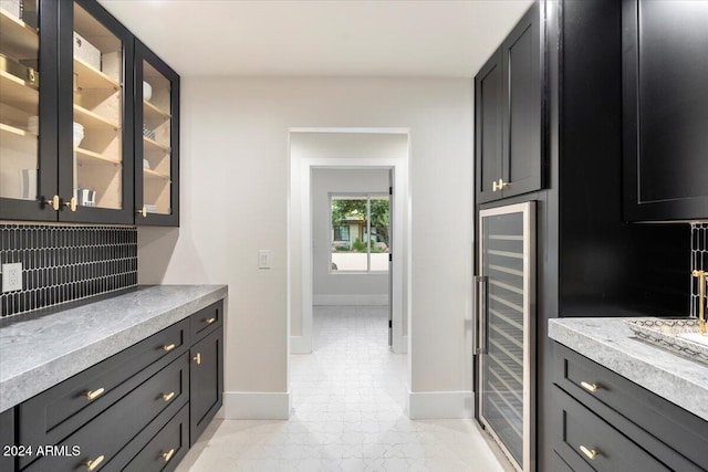 kitchen with wine cooler and light stone counters