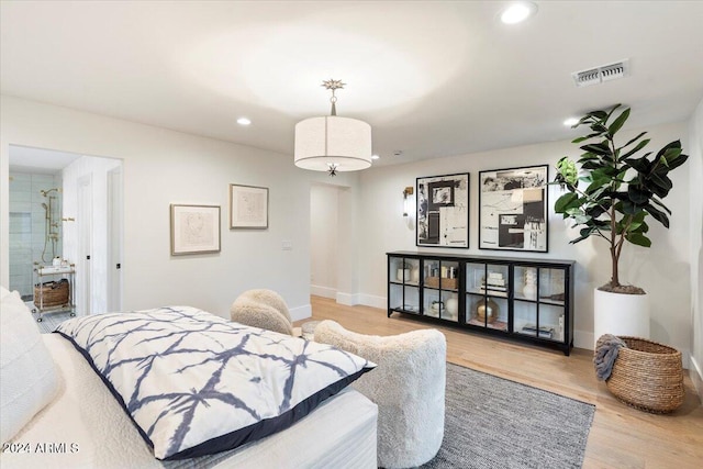 bedroom featuring wood-type flooring and ensuite bath