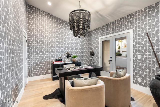 home office with light hardwood / wood-style floors, an inviting chandelier, and french doors