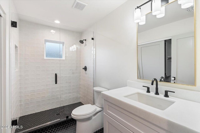 bathroom featuring vanity, toilet, and a shower with shower door