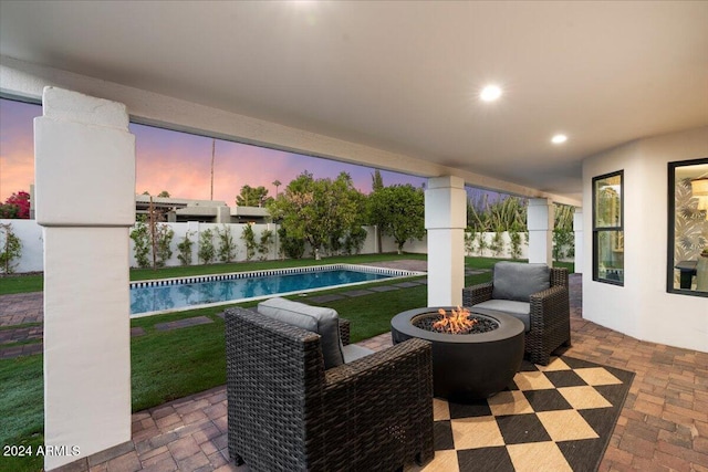 pool at dusk featuring a patio area and a fire pit