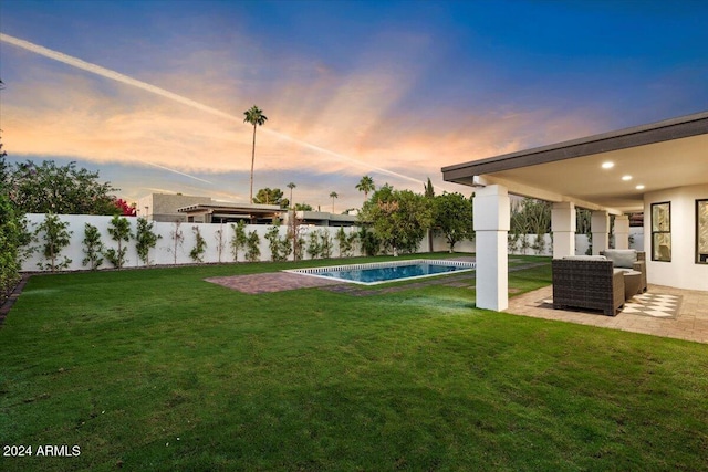 yard at dusk with a fenced in pool and a patio area