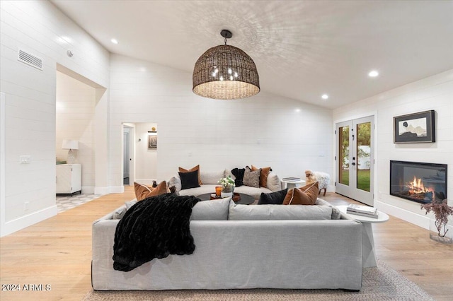 living room featuring lofted ceiling and light hardwood / wood-style floors