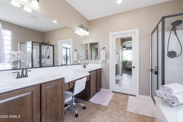 bathroom with vanity, a healthy amount of sunlight, tile patterned flooring, and a shower with door