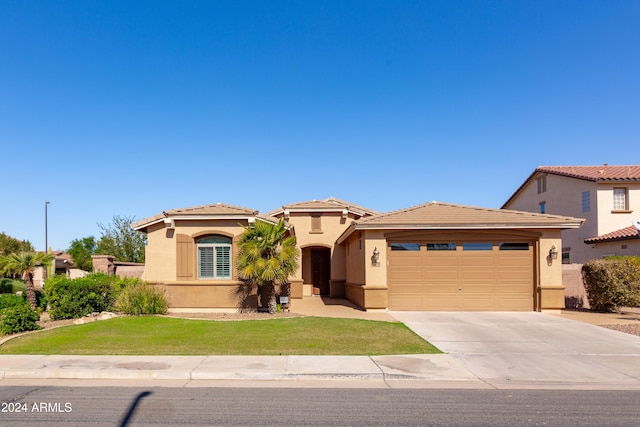 mediterranean / spanish-style home featuring a front yard and a garage