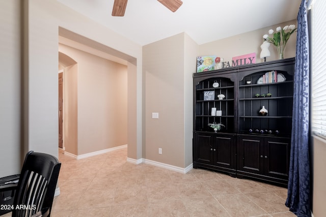 tiled home office featuring ceiling fan