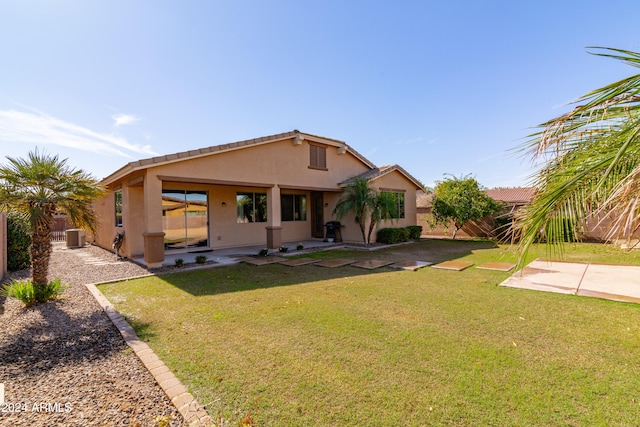 view of front of property featuring a patio, a front lawn, and central AC