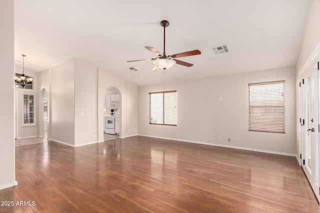 interior space featuring arched walkways, ceiling fan, wood finished floors, and visible vents