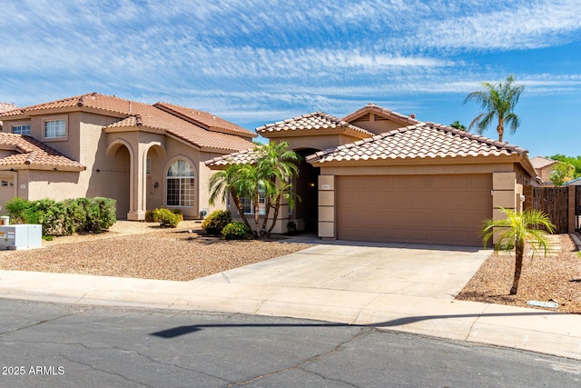 mediterranean / spanish house with an attached garage, concrete driveway, and stucco siding
