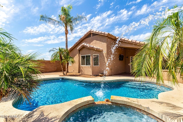 view of pool with a pool with connected hot tub, a fenced backyard, and a patio area