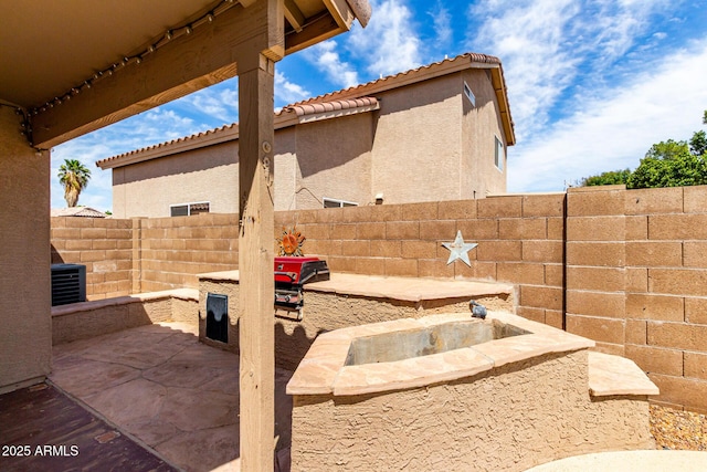 view of yard with a fenced backyard, a patio, cooling unit, and area for grilling