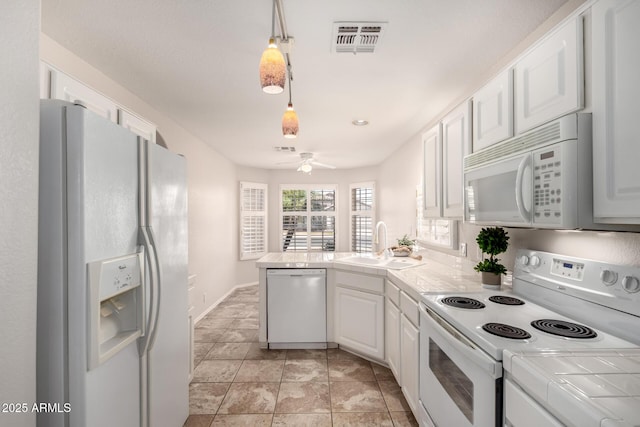 kitchen featuring visible vents, a peninsula, white appliances, tile countertops, and a sink