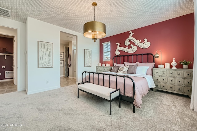 bedroom featuring connected bathroom and light colored carpet