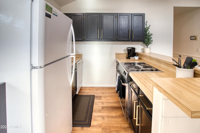 2273 Trail Cir, Overgaard, AZ 85933 - kitchen with freestanding refrigerator, stainless steel range oven, light wood-type flooring, a peninsula, and dark cabinets