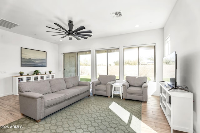 living area featuring light wood finished floors, visible vents, and a healthy amount of sunlight