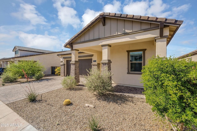 8140 E June St, Mesa, AZ 85207 - view of front facade with board and batten siding, driveway, a garage, and stucco siding