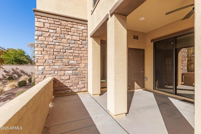 doorway to property with a balcony and ceiling fan