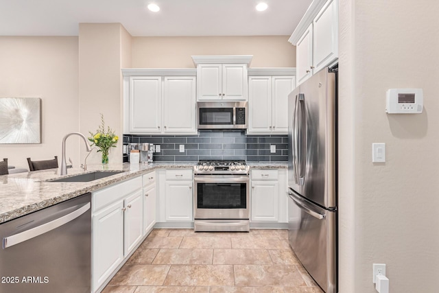 kitchen featuring white cabinetry, stainless steel appliances, sink, and decorative backsplash