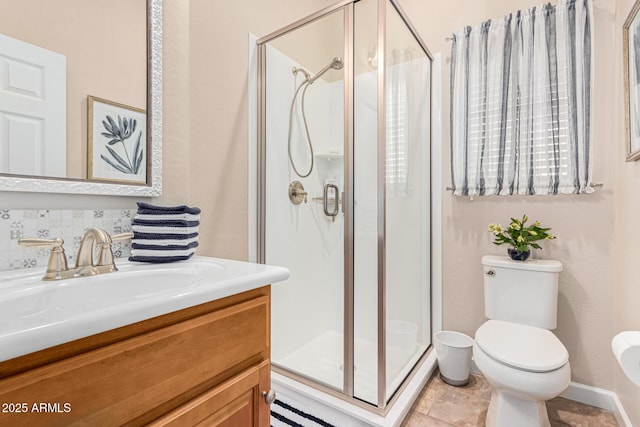 bathroom featuring tasteful backsplash, vanity, toilet, and a shower with shower door