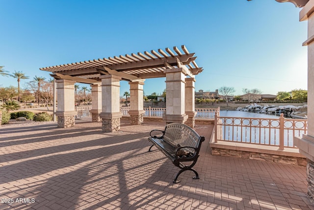 view of patio / terrace featuring a pergola and a water view