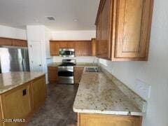 500 S Santa Fe Trl, Cornville, AZ 86325 - kitchen featuring appliances with stainless steel finishes, a sink, brown cabinets, and light countertops