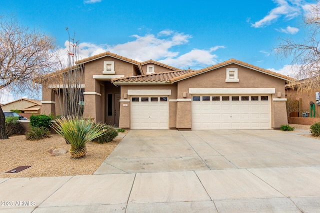 view of front of house featuring a tile roof, an attached garage, driveway, and stucco siding