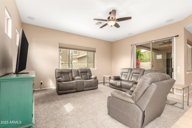 living area with visible vents, baseboards, and a ceiling fan