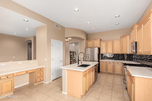 kitchen featuring visible vents, light brown cabinets, a sink, arched walkways, and appliances with stainless steel finishes