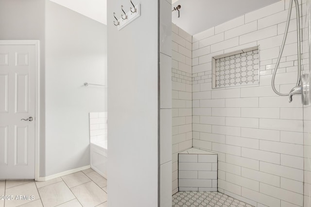 full bath with a tile shower, a bath, and baseboards