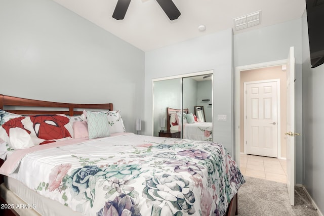 carpeted bedroom with tile patterned flooring, visible vents, ceiling fan, vaulted ceiling, and a closet