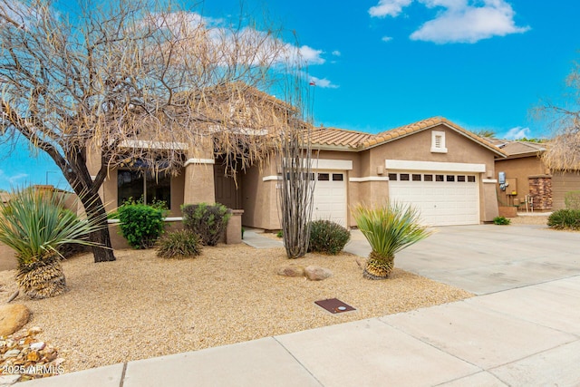 view of front facade with stucco siding, a garage, driveway, and a tile roof