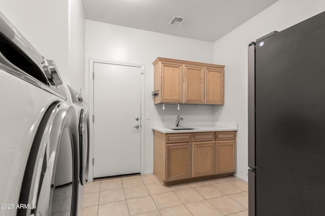 interior space with visible vents, washer / clothes dryer, freestanding refrigerator, a sink, and light countertops