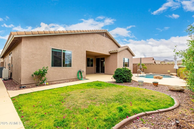 back of house with a fenced in pool, stucco siding, a yard, a fenced backyard, and a patio area