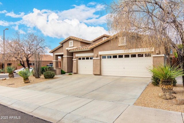 view of front of house with a tile roof, concrete driveway, a garage, and stucco siding