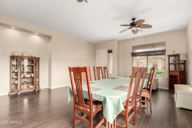 dining space with baseboards, a ceiling fan, and wood finished floors