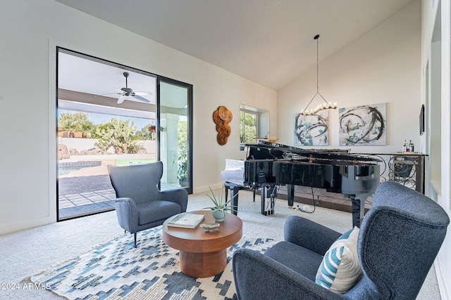 sitting room with vaulted ceiling, ceiling fan with notable chandelier, carpet, and baseboards