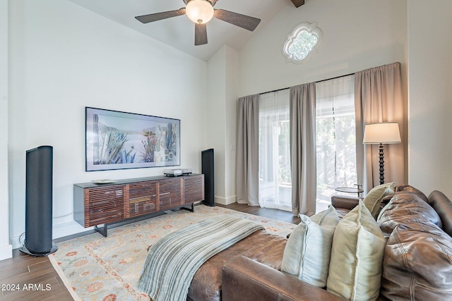 bedroom with ceiling fan, high vaulted ceiling, wood finished floors, and baseboards