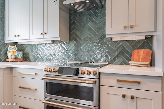 kitchen featuring light countertops, ventilation hood, backsplash, and double oven range